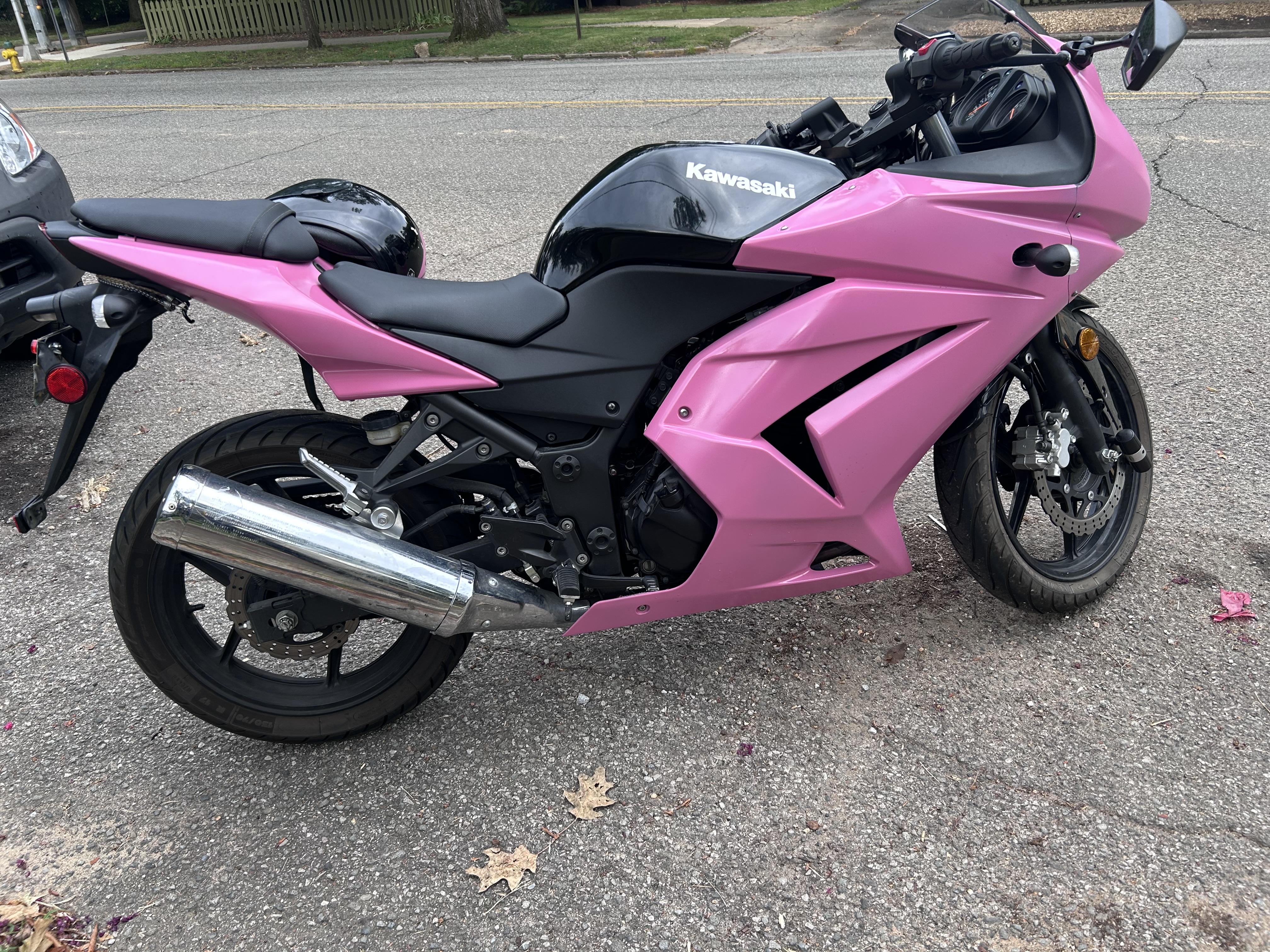 Image of a 2008 Kawasaki Ninja 250r sports motorcycle with Pink upper and lower fairings and a black front fender, gas tank, and frame.